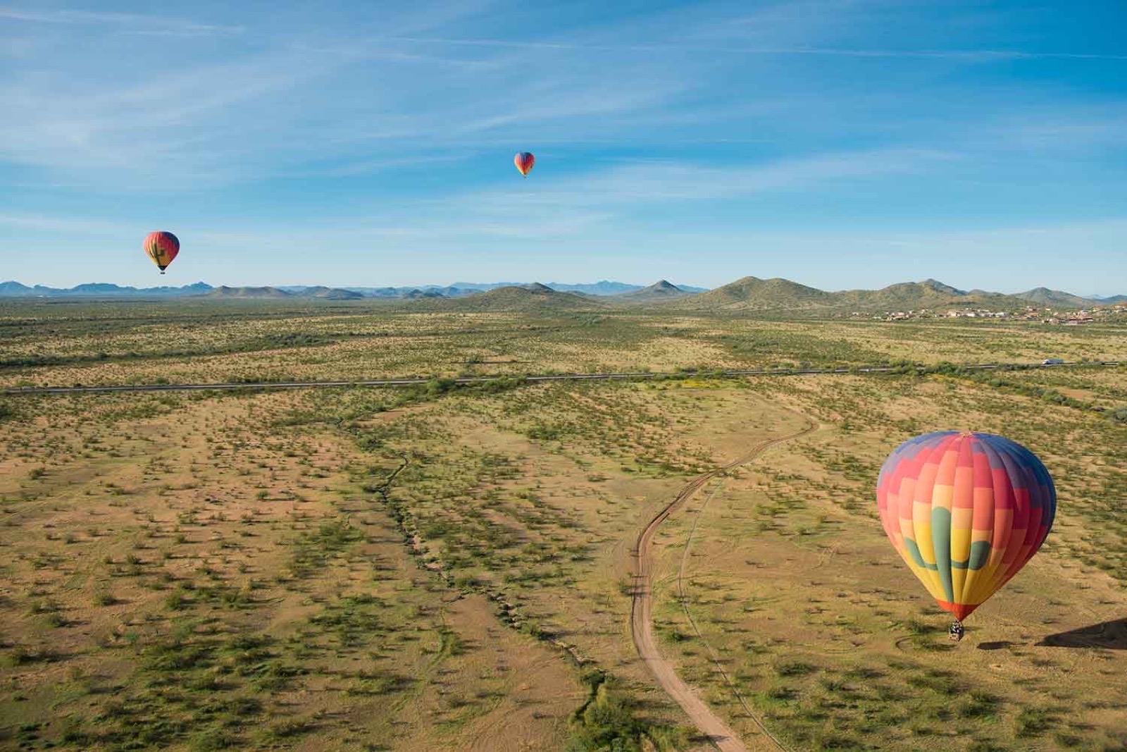 Three hot air balloons floating over the Sonoran Desert